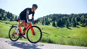 Cyclist riding a red Pinarello Paris road bike in the mountains