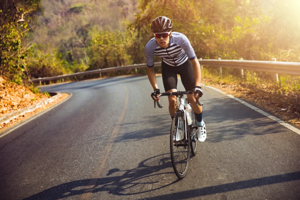 Road cyclist riding on a quiet forest road