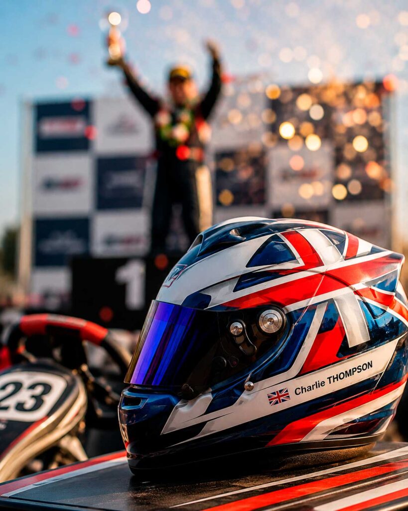 Personalised karting helmet at a race podium