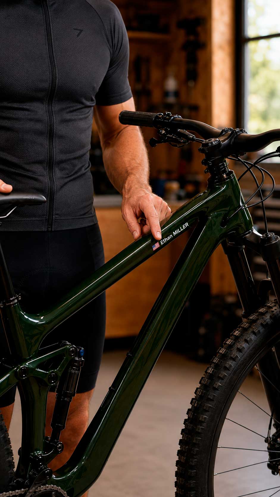 Cyclist pressing a name sticker with a USA flag onto a green full-suspension mountain bike